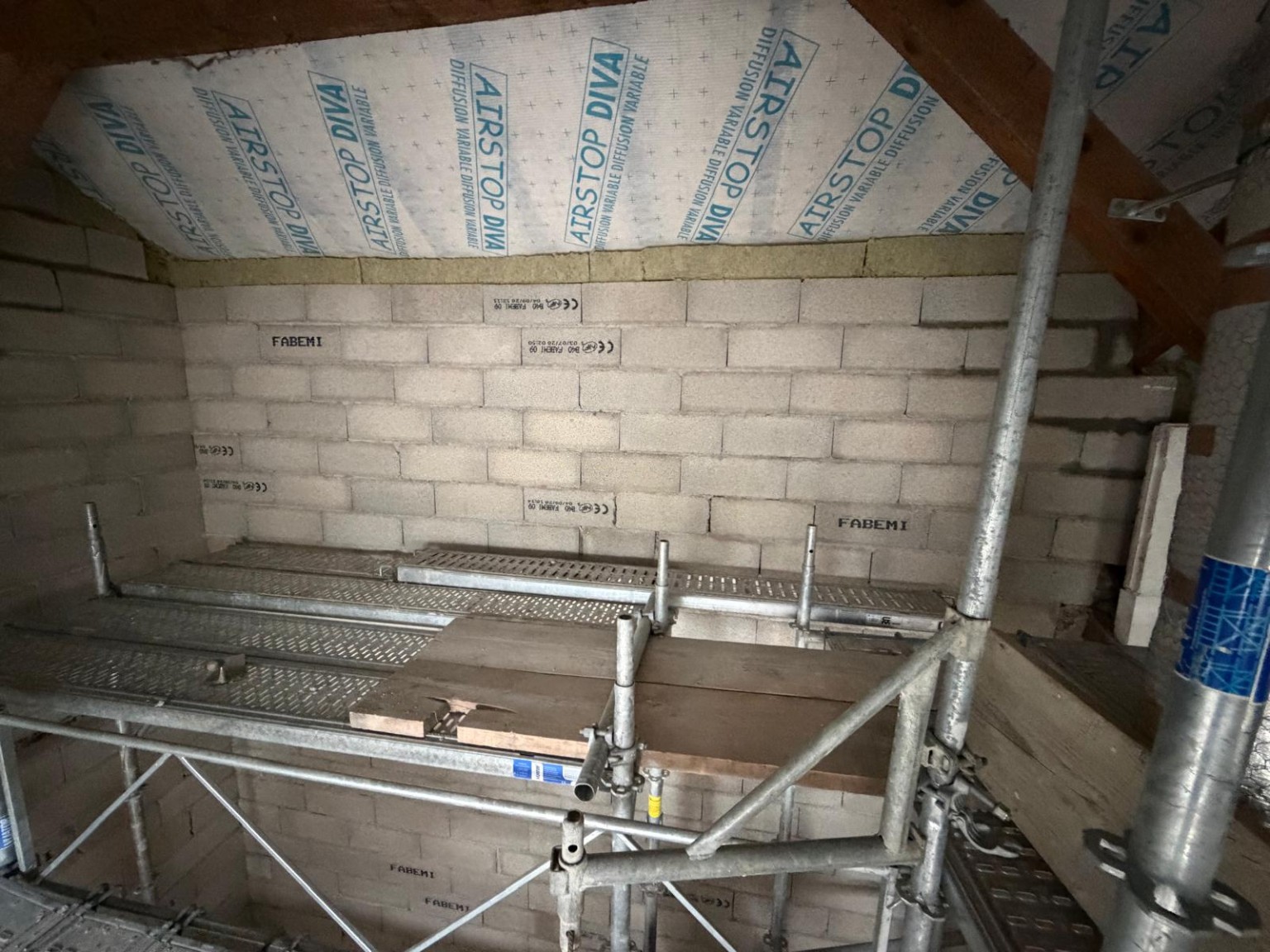 Avancement du mur en blocs de béton sous la toiture