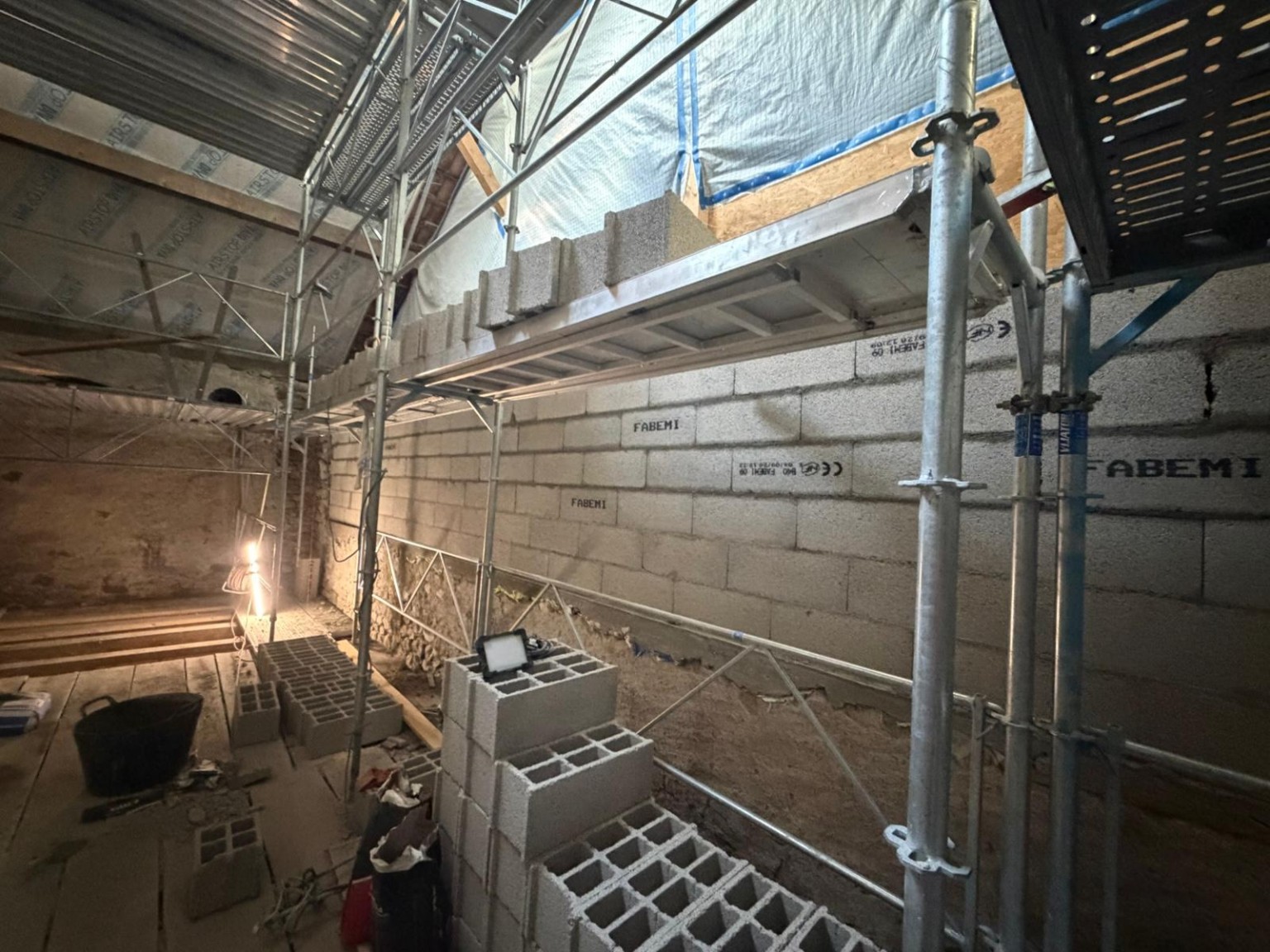 Élévation du mur en blocs de béton avec échafaudage sur le chantier